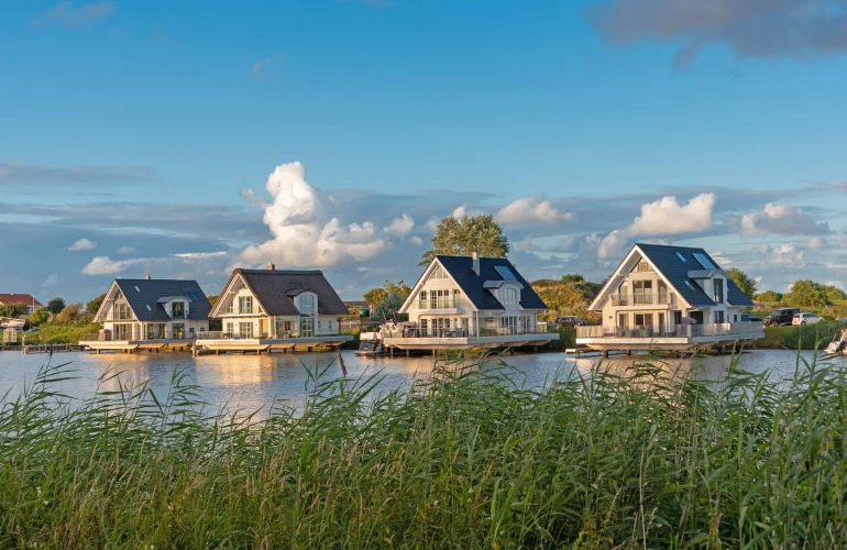 Vier Häuser mit Satteldach auf dem Wasser