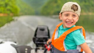 Jongen in boot op het water